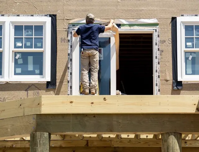 Whitcomb Building & Remodeling carpenter flashing a sliding door on a waterfront Cape Cod property